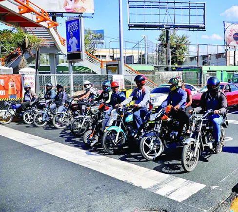 Varios motociclistas esperando que el semáforo dé el paso.