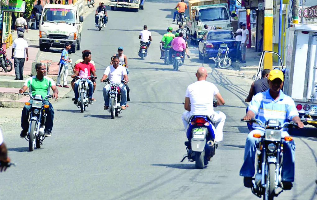 Motociclistas transitando en las calles sin el casco protector, un requisito para moverse en estos vehículos de motor.
