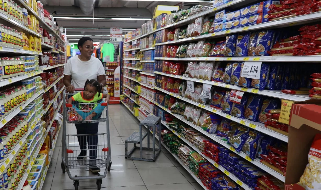 Una madre en el supermercado mientras visualiza  el precio de las pastas.  Arlenis castillo