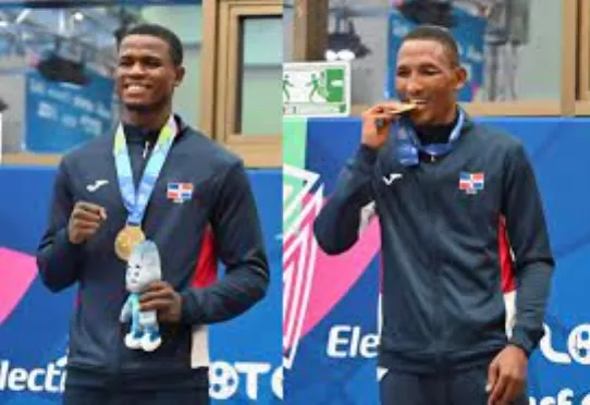 Cristian Pinales y Alexy de la Cruz exhiben medalla alcanzada en los pasados Juegos Centroamericanos y del Caribe.