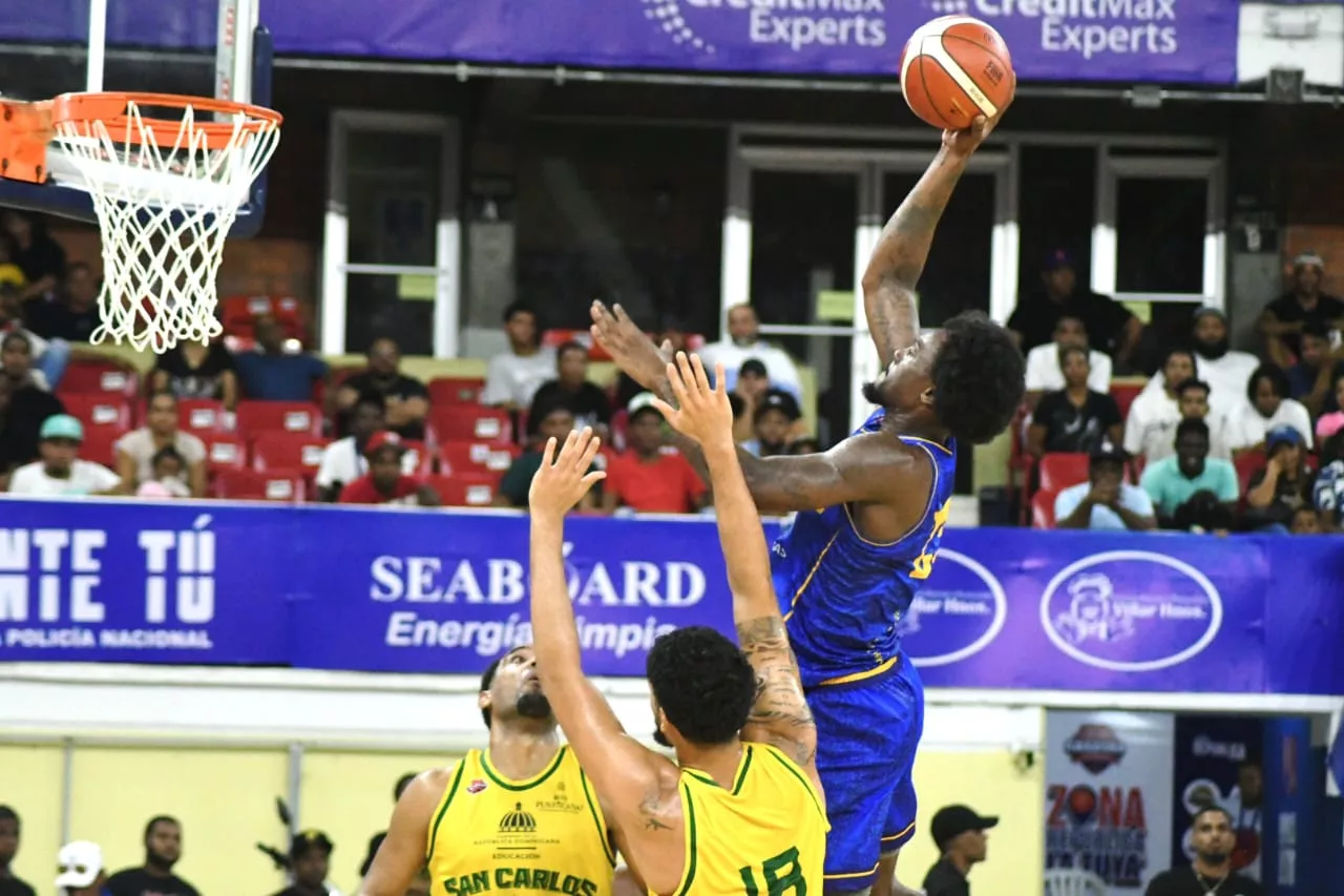 Emmit Williams, del club Mauricio Báez, lanza entre los defensas de San Carlos, Juan Guerrero y Richard Núñez.
