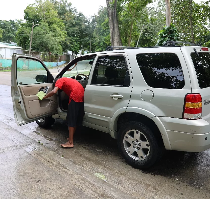 Un joven mientras se dedica al lavado de autos.  Arlenis castillo
