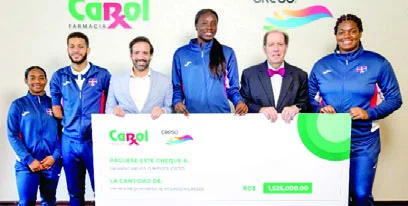 Atletas reciben incentivo de manos de los ejecutivos de la la Farmacia Carol.