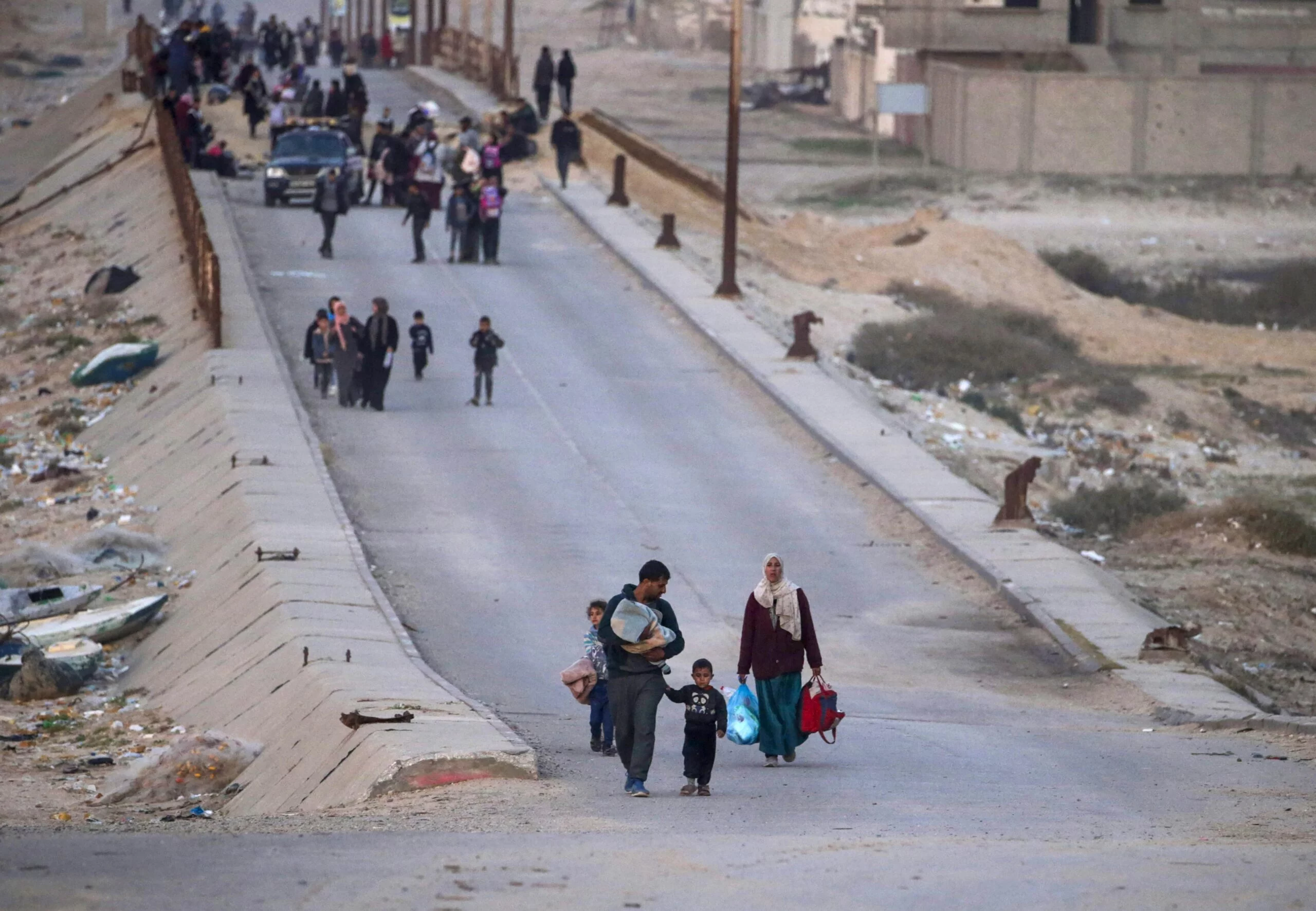 Palestinians walk along coast road from northern to southern Gaza