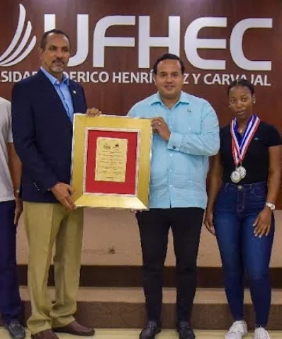 Alberto Ramírez, rector de la UFHEC, recibe la placa.