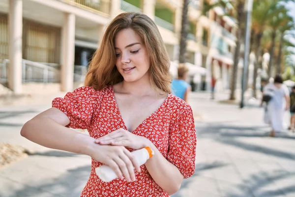 Young caucasian girl smiling confident using sunscreen at street