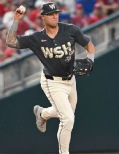 El tercera base  Nick Senzel intenta lanzar la pelota.