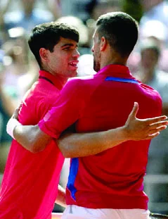 Carlos Alcaraz y Novak Djokivic se abrazan tras el partido.