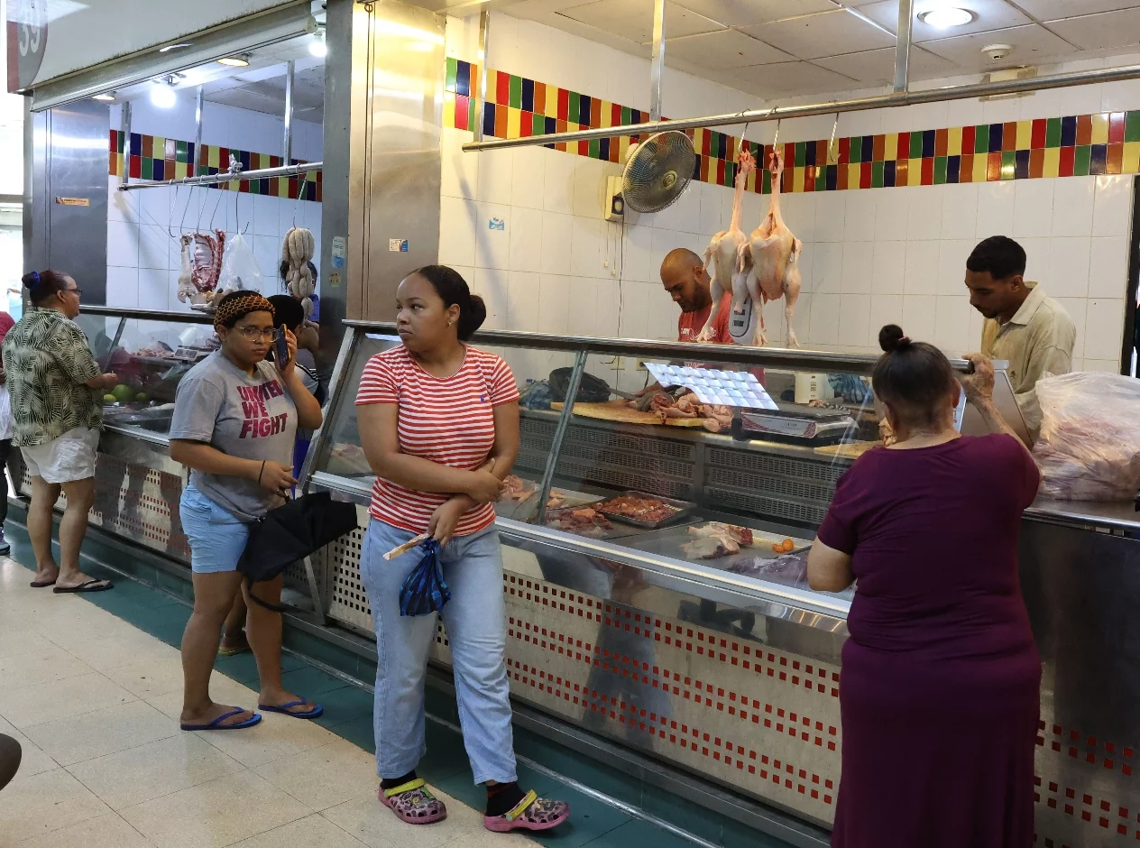 Consumidores observando disponibilidad de pollo  en las góndolas del mercado público.