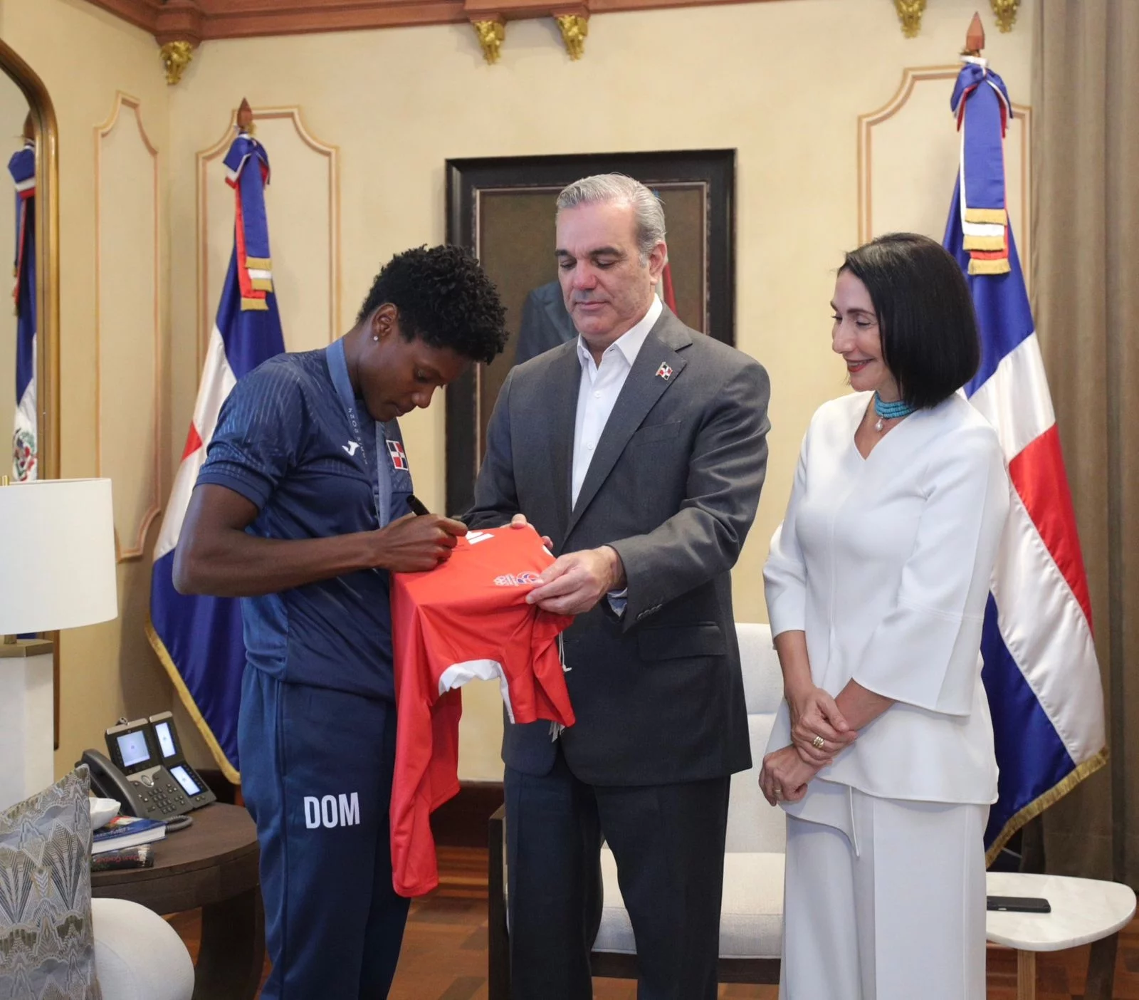 Marileidy Paulino firma una camiseta al presidente Luis Abinader y la primera dama Raquel Arbaje.