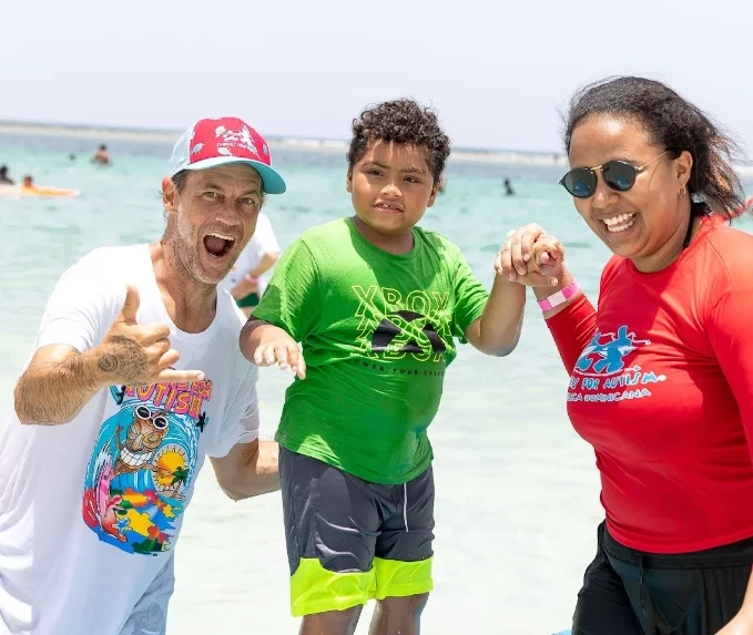 Niño junto a directivos y  voluntarios de ‘Surfers for Autism’.