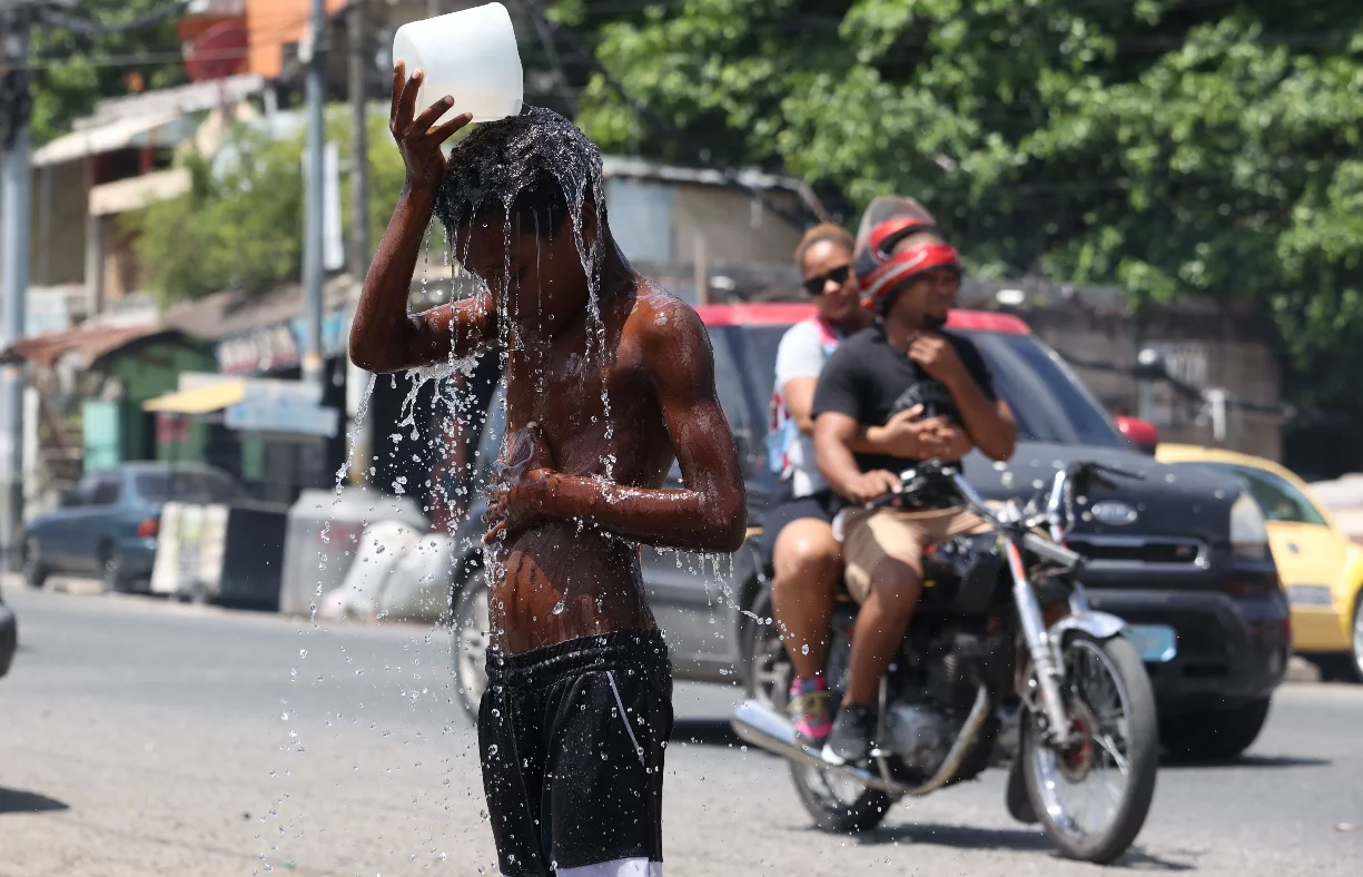Niño en el sector Los Guandules   mientras se echaba agua para lidiar con el calor.  Elieser Tapia