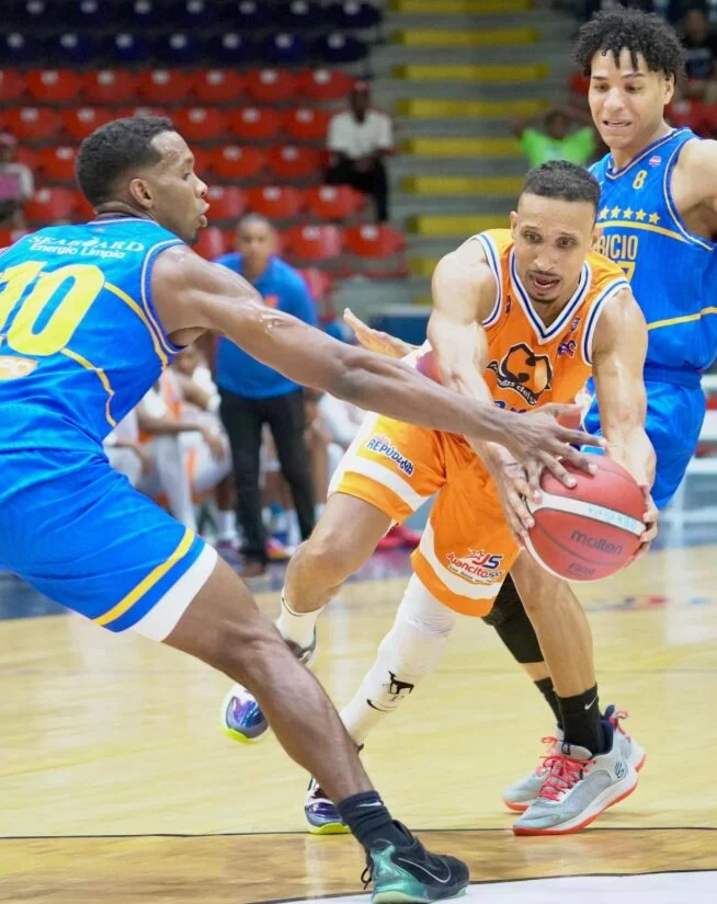 Adris de León intenta burlar la defensa de los jugadores Gerardo Suero y Richard Bautista.