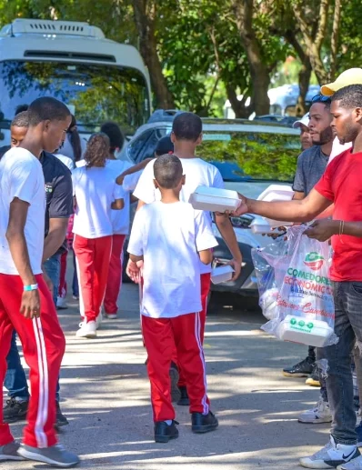 Miembros de los comedores entregan alimentos.