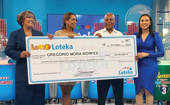 Ynmaculada Liriano, directora ejecutiva de Loteka,  entrega  el premio a Gregorio Mora.