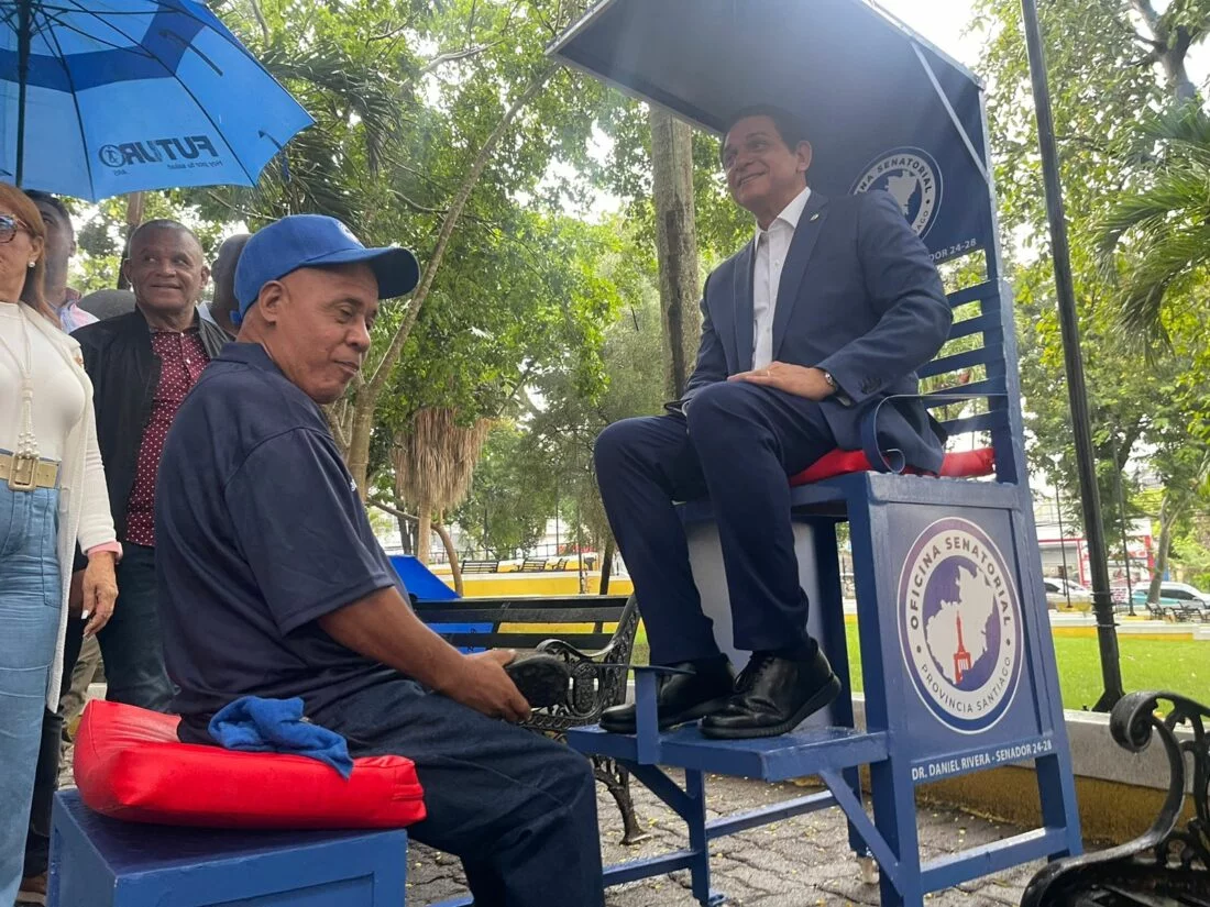 El señor limpiabotas Virgilio Cruz, posa junto al senador Daniel Rivera, en el parque Los Chachases, de Santiago. Fuente externa