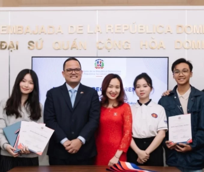 Representante de la embajada junto a estudiantes.