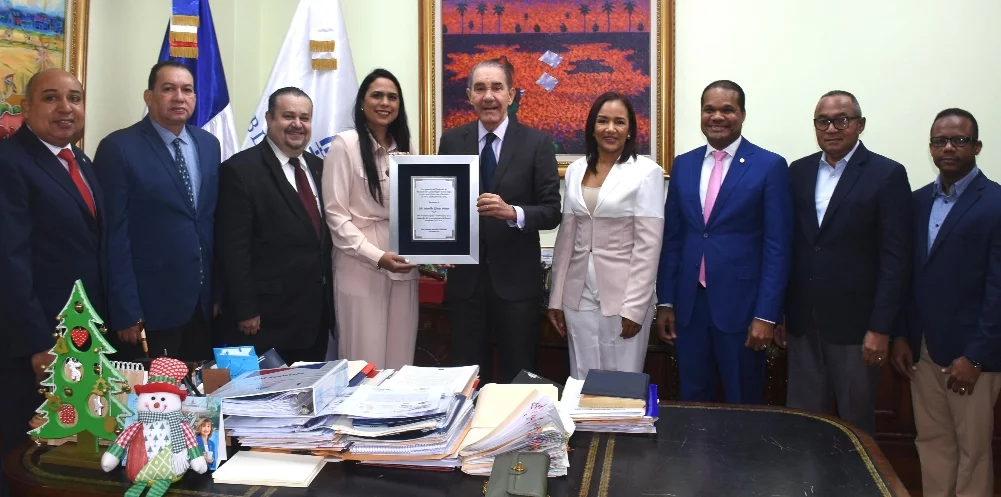 Egresados de Nova Southeastern University entregan el reconocimiento a Franklin García Fermín.