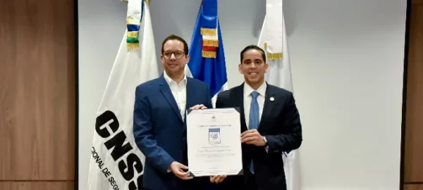 Sigmund Freund entrega la certificación al gerente general del CNSS, Edward Guzmán.