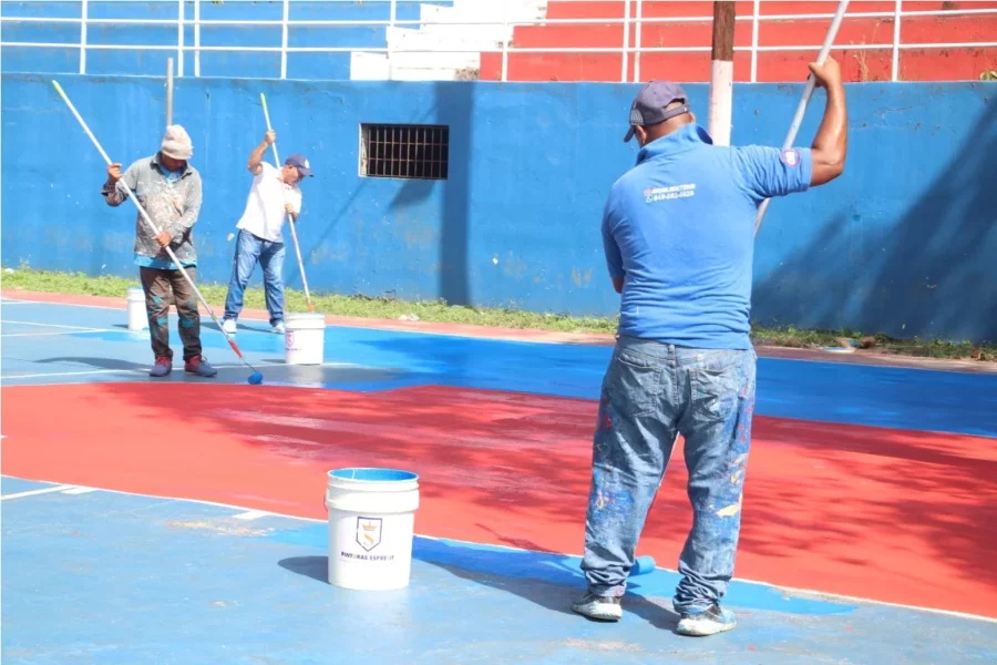 PIE DE FOTO TRABAJADORES DEL INEFI MIENTRAS PINTABAN UNA DE LAS CANCHAS.