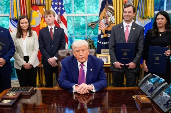 El presidente estadounidense, Donald Trump (C), firma órdenes ejecutivas y habla con los periodistas en el Despacho Oval de la Casa Blanca.