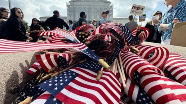 Se ven banderas estadounidenses durante una protesta frente a la Corte Suprema de Estados Unidos por la decisión del presidente Donald Trump de poner fin a la ciudadanía por derecho de nacimiento, mientras el tribunal escucha argumentos sobre la orden en Washington, el 15 de mayo.
