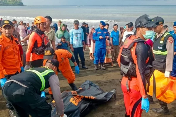 Un equipo de rescate cubre el cadáver de una víctima del naufragio, hallado antes por unos pescadores locales, el 3 de julio de 2025 en una playa de Banyuwangi, en la isla indonesia de Bali, una imagen divulgada por la agencia nacional de emergencias