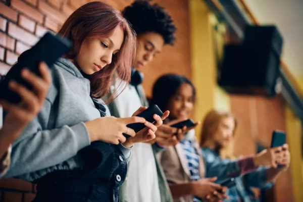 group-of-teenagers-using-mobile-phones-in-hallway-2023-11-27-05-05-30-utc-scaled