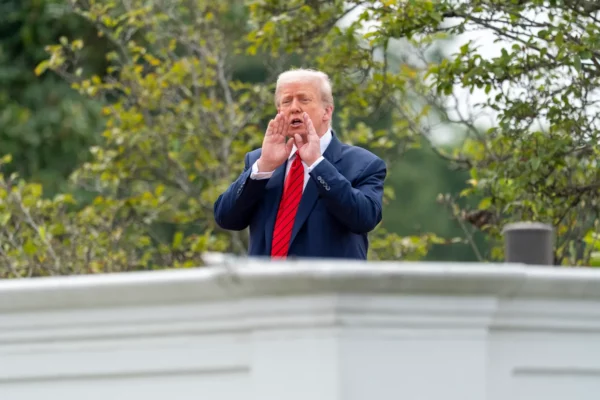 El presidente Donald Trump grita a los reporteros mientras inspecciona los terrenos desde el techo arriba de la columnata que va hacia el Ala Oeste de la Casa Blanca, el martes 5 de agosto de 2025, en Washington.