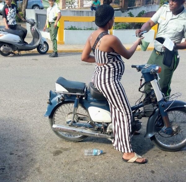 Embarazada que conducía una motocicleta sin casco protector.