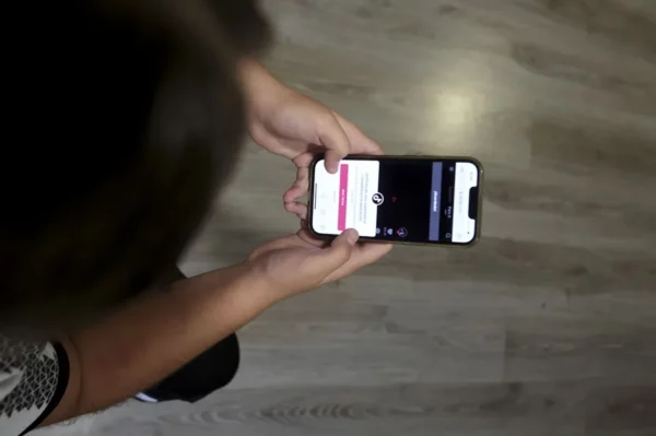 Una chica consulta su teléfono móvil.