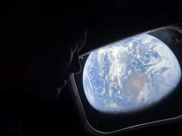 El comandante Reid Wiseman observa la Tierra mientras continúan adentrándose en el espacio hacia la Luna. EFE/ NASA